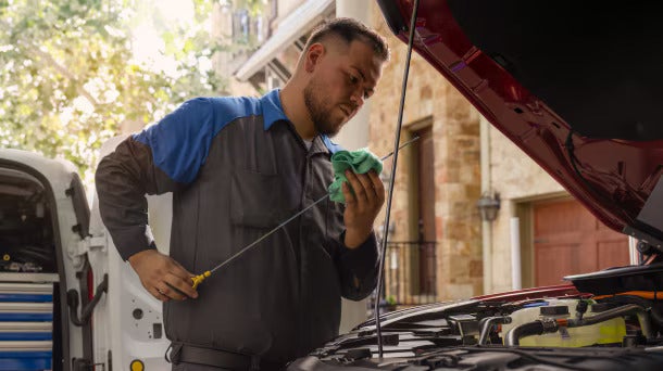 a ford technician checking the oil in a vehicle